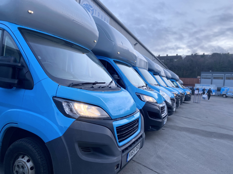 Fleet of Trunk Logistics removal vans parked at Essex warehouse facility