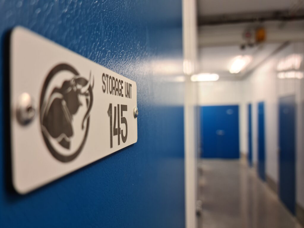 Indoor self storage corridor with secure blue storage rooms at Trunk Self Storage in Grays, Essex