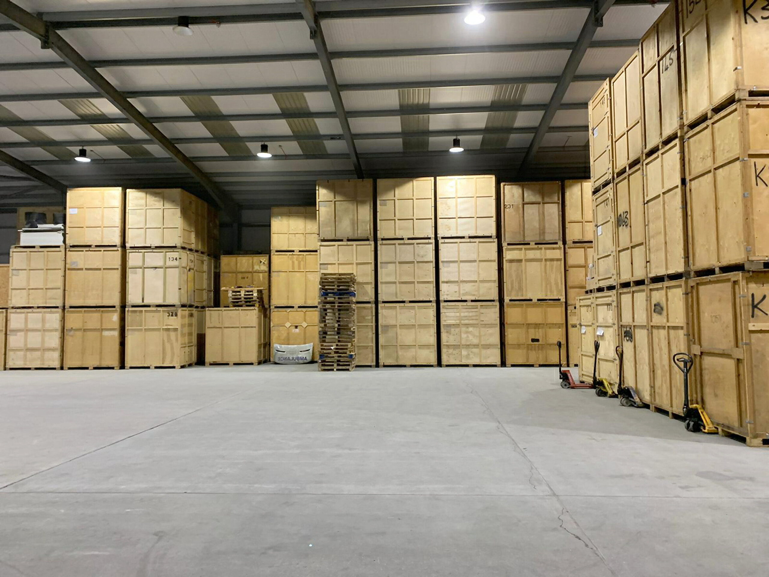 High-stacked wooden storage crates inside secure Grays warehouse facility