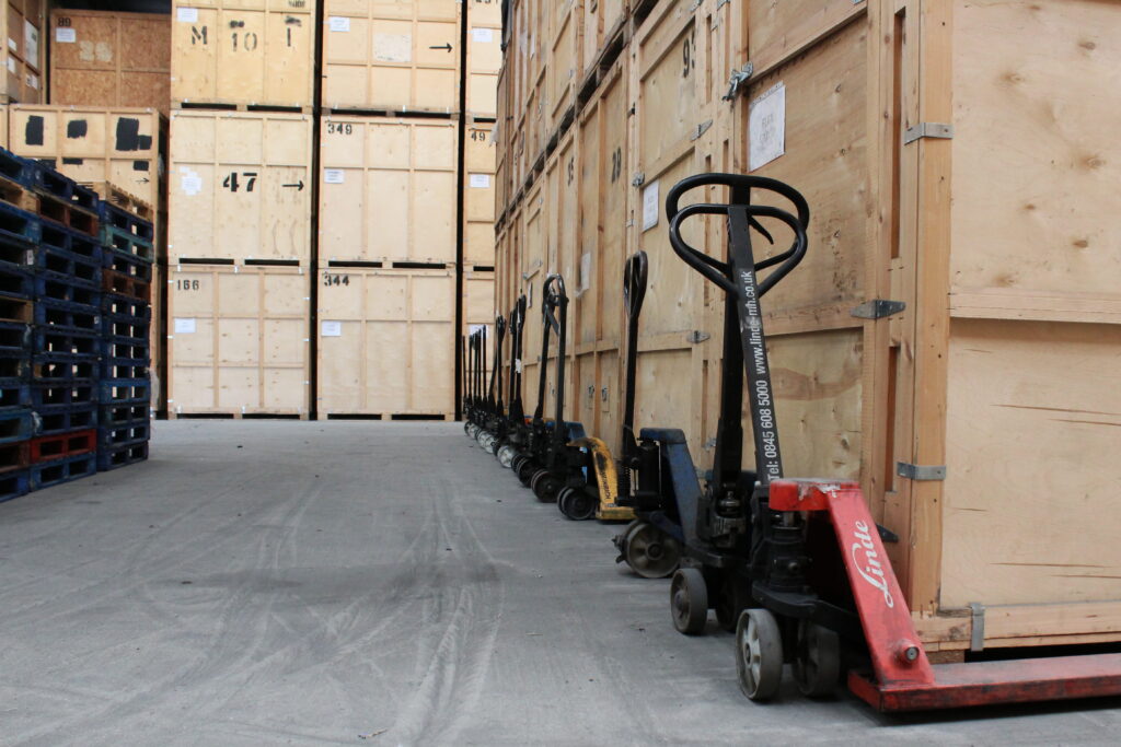 Pallet trucks beside stacked wooden storage crates at Unit 54 warehouse in Grays Essex