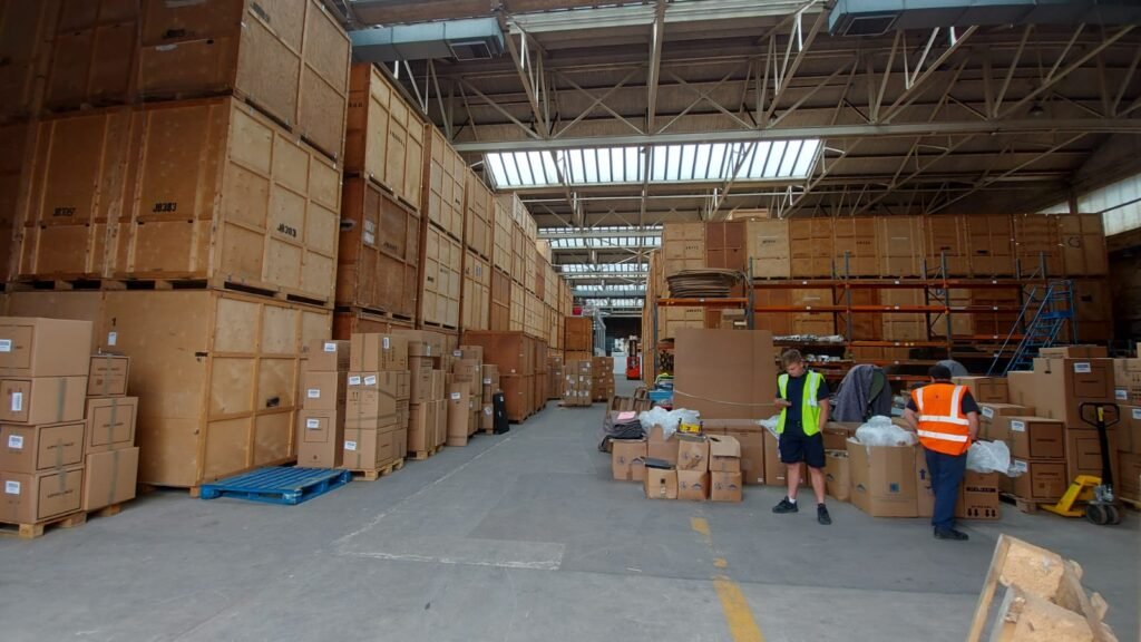 Warehousing and Logistics Warehouse staff organising boxed inventory inside secure Essex storage facility