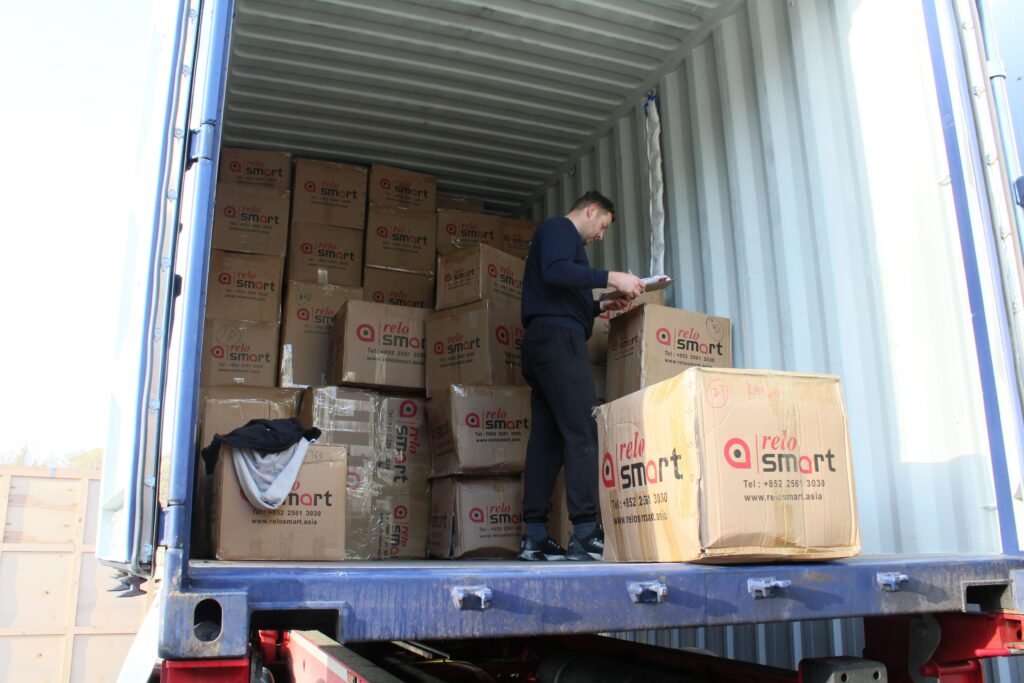 Last Mile Warehousing for London, Essex and Kent Inside open shipping container showing Trunk Logistics operative checking import goods before devanning at Grays Essex warehouse