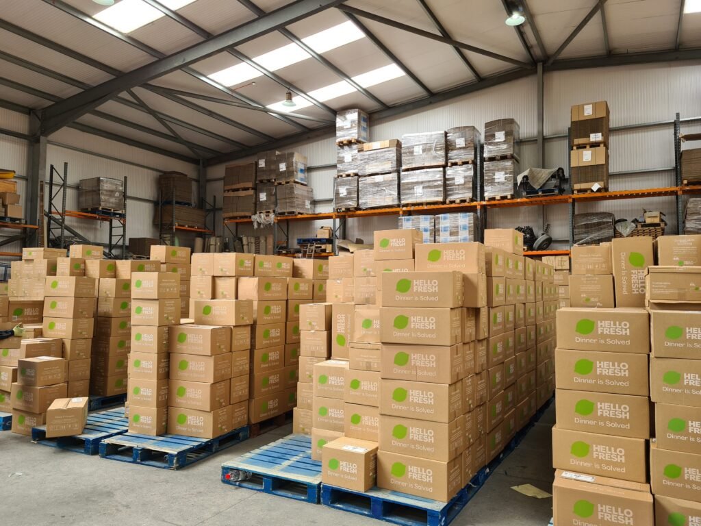 Overnight Food Box Sortation Interior of Trunk Logistics commercial warehouse in Grays Essex showing large volume of palletised goods on blue pallets with racking system