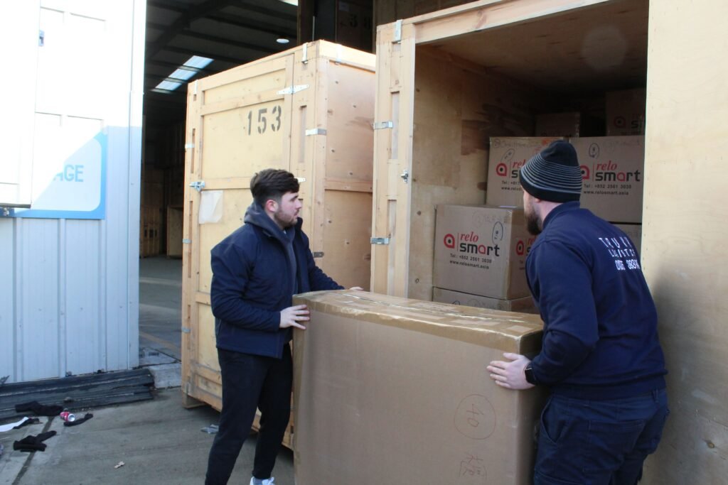 Trunk Logistics team unloading large boxed goods from wooden storage crate at commercial warehouse in Grays Essex