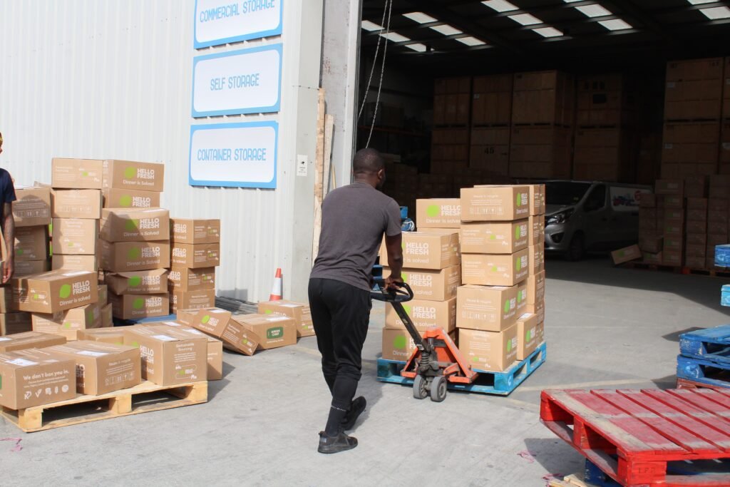 Trunk Logistics warehouse loading bay in Grays Essex showing pallet jack operative with commercial storage and self storage signage visible